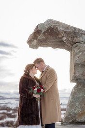 Bride and groom touching foreheads smiling with sun in the background