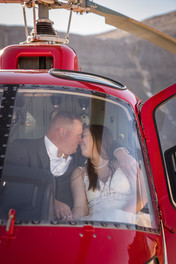 bride and groom smile and kiss in helicopter
