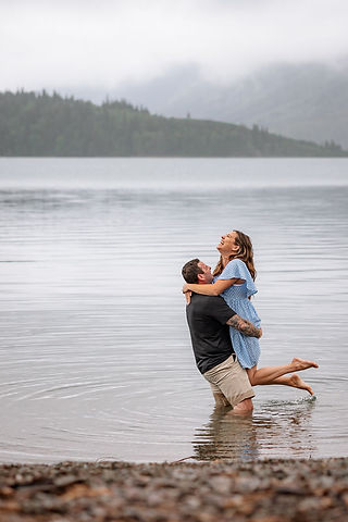 Playful moment of a woman laughing while the man lifts her in a quiet embrace captured by a Waterton Park wedding photographer.