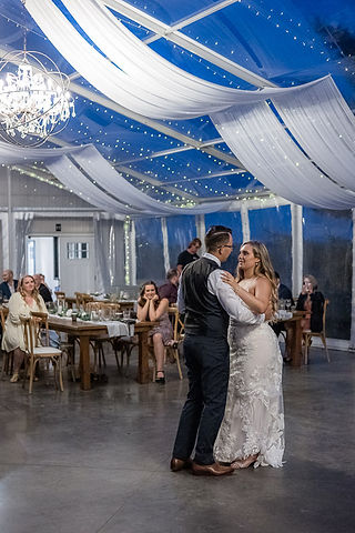 bride smiles at groom at first dance 