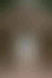 White wedding dress hanging from a wooden outdoor structure with greenery and trees in the background at a Coutts Centre wedding.