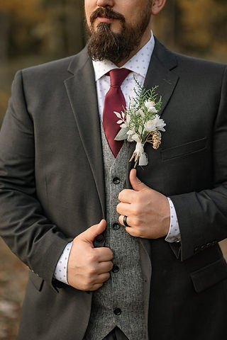 Groom portrait featuring a boutonniere during a mountain wedding in Kananaskis