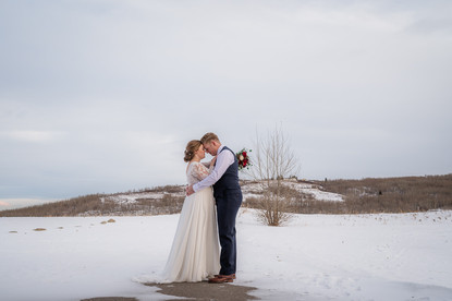 Bride and groom dancing against prairie landscape