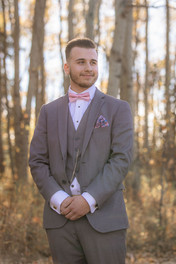 Groom smiles as he waits for bride