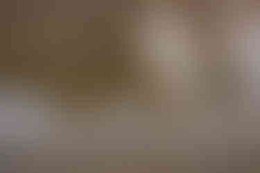 A romantic reflection of a couple holding hands and gazing at each other in the crystal-clear waters of Bow Lake, with smooth rocks visible beneath the surface, creating a serene and intimate scene.