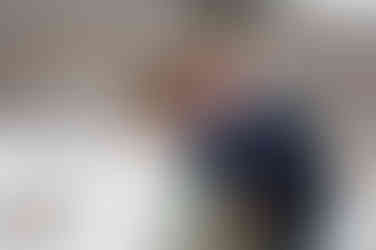 Bride and groom smiling as they rest their foreheads against one another