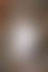 A vertical shot of detailed shot of the bride’s cowgirl boots, vow book, jewelry, bouquet, and perfume bottle.