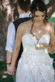 Bride and groom holding hands, bride reading her personalized vows to him