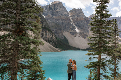 Couple embrace infront of Moraine Lake for engagement