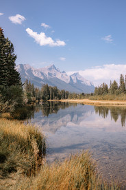 Mountain lake at Rundleview Parkette reflecting the Rocky Mountains, creating a stunning natural backdrop
