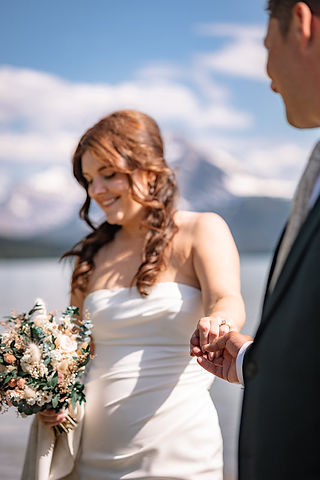 Bride holding her bouquet and the grooms hand during her Peyto Lake elopement