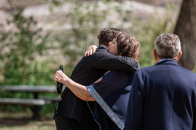 Groom going his mother a hug at ceremony