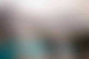 Bride and groom embracing on a big rock overlooking Moraine Lake and the mountains.