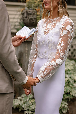 Close-up of the bride and groom holding hands as the groom reads his vows during a private moment at their Bragg Creek wedding