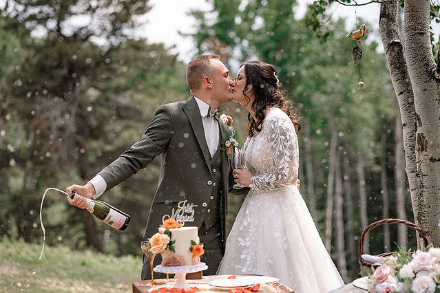 bride and groom doing champagne toast with cake