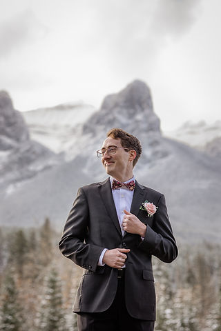 Portrait of groom smiling with mountain top in background