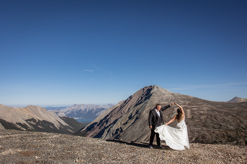 groom spins bride as they look out over mountains