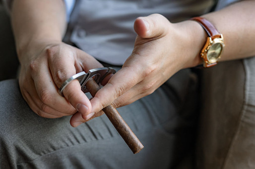 Detail shot of Groom cutting his cigar 