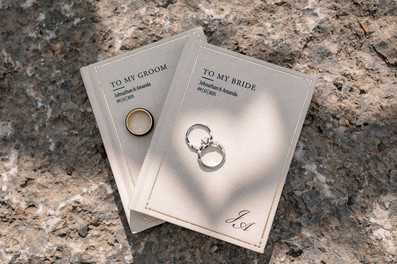 Close-up of wedding rings resting on the bride and groom’s vow books at The Sensory Canmore.