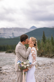Newlyweds sharing a kiss in the mountains near their Kananaskis wedding