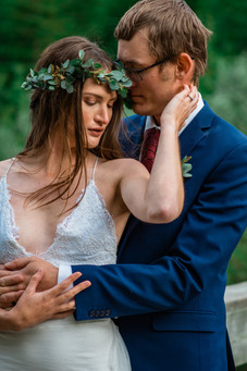 Bride touching her groom's face while standing in front of him.