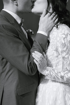 black and white of bride and groom kissing