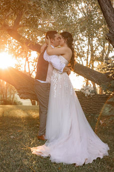 bride and groom kissing under tree