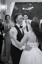 Bride and groom sharing their first dance indoors in black and white, captured by a Southern Alberta wedding photographer.