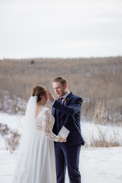 Groom wiping tears from brides face