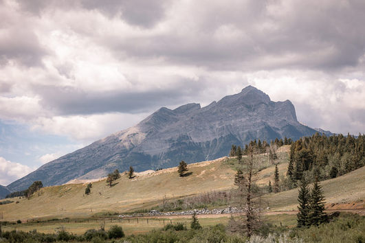 Mountain landscape with rolling hills and cloudy skies on their Crowsnest Pass wedding day