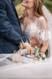 Bride and groom sharing a joyful moment during their Canmore Nordic Centre wedding, with the bride holding her bouquet against the stunning Rocky Mountain backdrop.