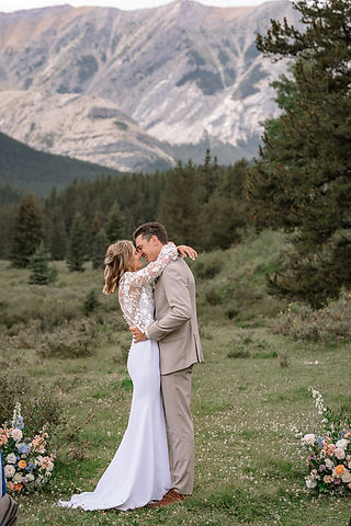 Breathtaking mountain ceremony as the bride and groom share a kiss during an intimate Kananaskis wedding