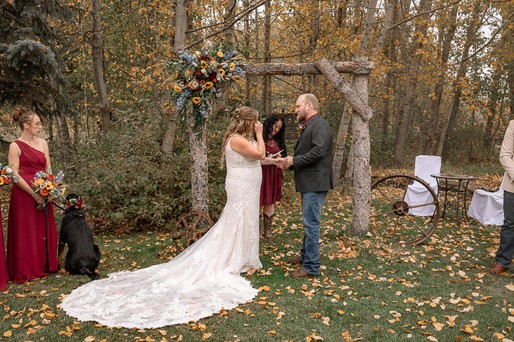 Romantic outdoor wedding ceremony at the Strathmore wedding venue featuring a rustic floral arch, fall leaves, countryside scenery, and heartfelt autumn wedding moments.