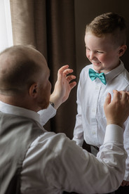 Groom helping son fix bow tie
