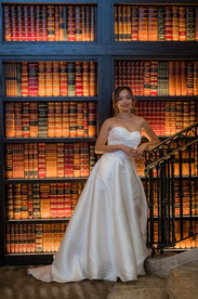 Bride leaning on staircase infront of library 
