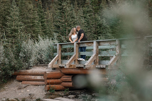 couple on bridge looking at one another surrounded by sage brush