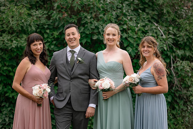 Groom smiling with bridesmaids