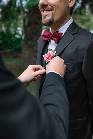 groomsmen putting on grooms boutinere