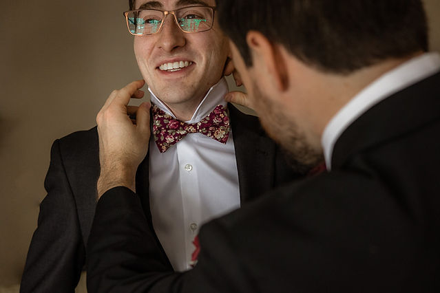 detail shot of grooms bow tie being adjusted