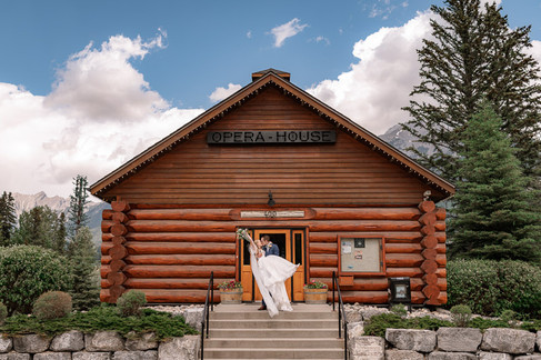 Bride and groom posing in front of the historic Opera House at one of the most charming Canmore wedding venues, surrounded by beautiful Rocky Mountain scenery.