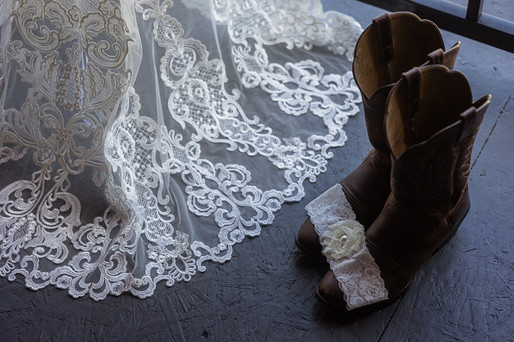 Bride's lace dress details, garter and cowboy boots