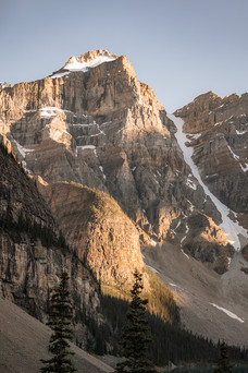 vertical shot of a tall rocky mountain peak against a bright blue sky