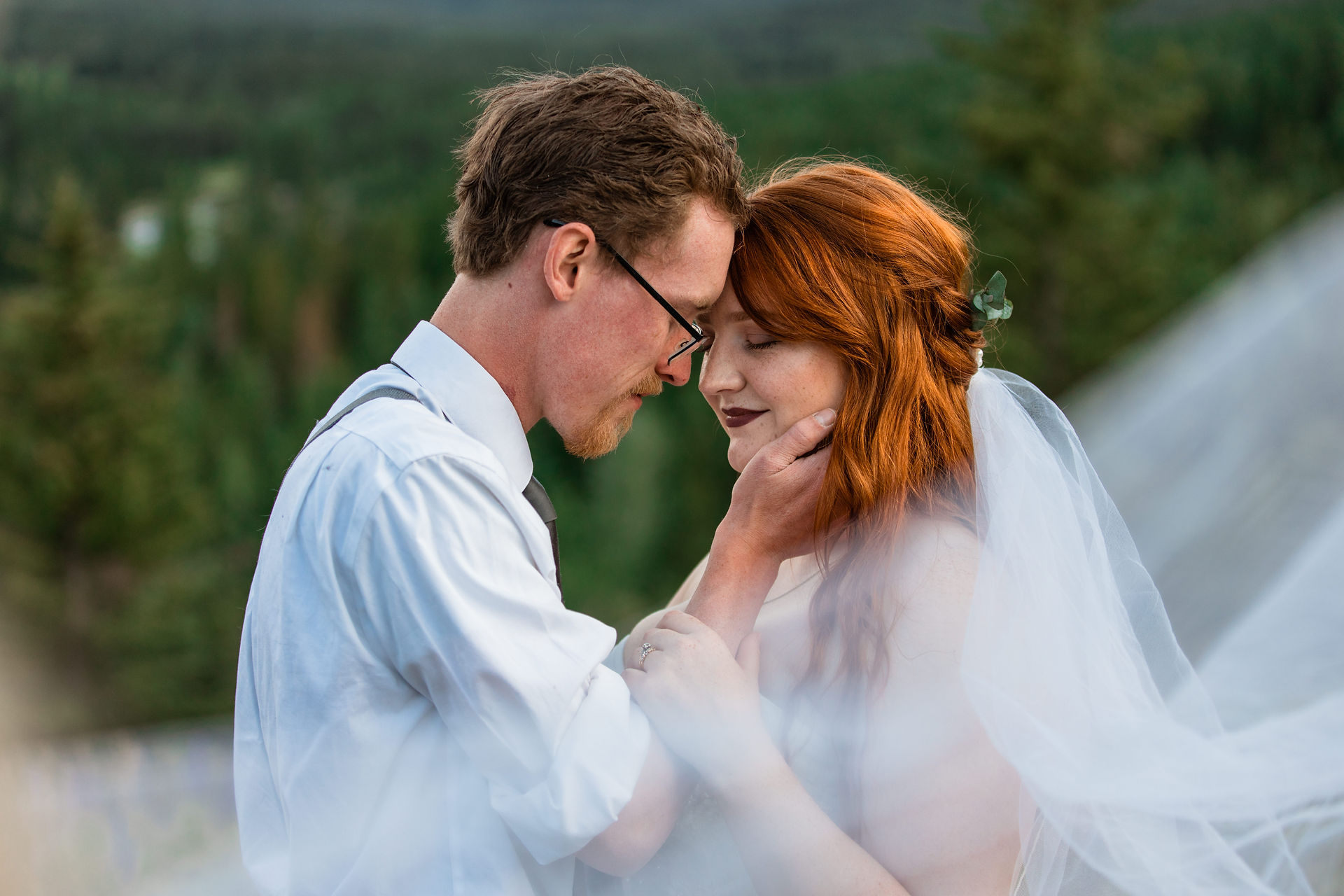 Bride and groom embracing, Groom is holding her face.