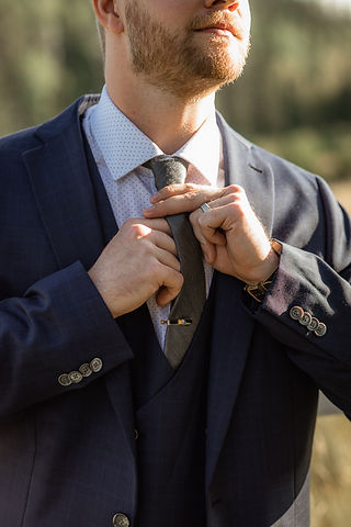Groom fixing his tie