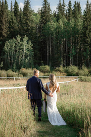 bride and groom looking at each other in a field of golden grasses