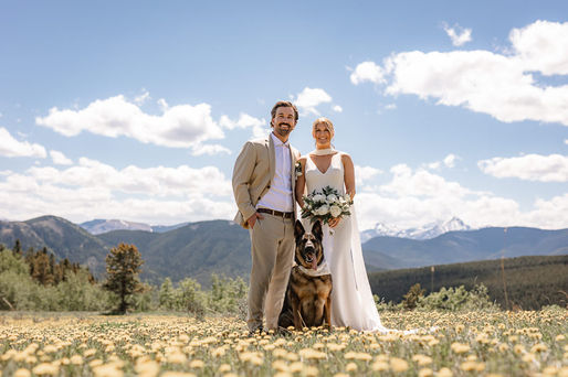 Bride, groom, and their dog posing for portraits at an Airbnb wedding venue