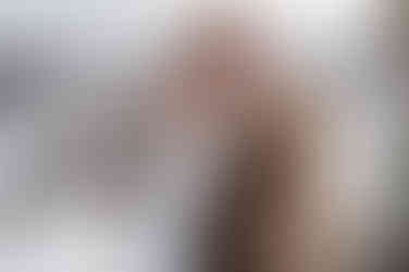 Bride smiling with groom nuzzling into her forehead