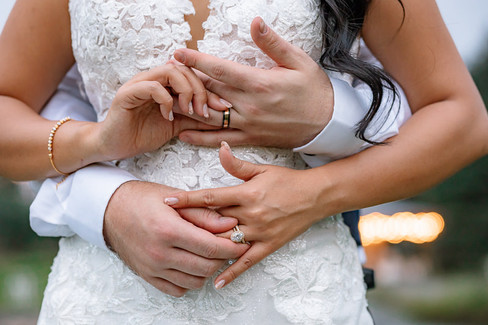 Bride and groom putting rings on to eachother, detail shot