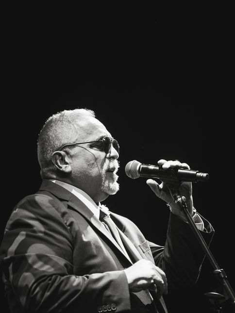 Willie Colón singing on stage during a concert at the Ritz Theatre in Elizabeth, NJ.