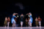 Eye-level view of the stage at The Ritz Theatre with dancers performing Swan Lake in elegant white costumes
